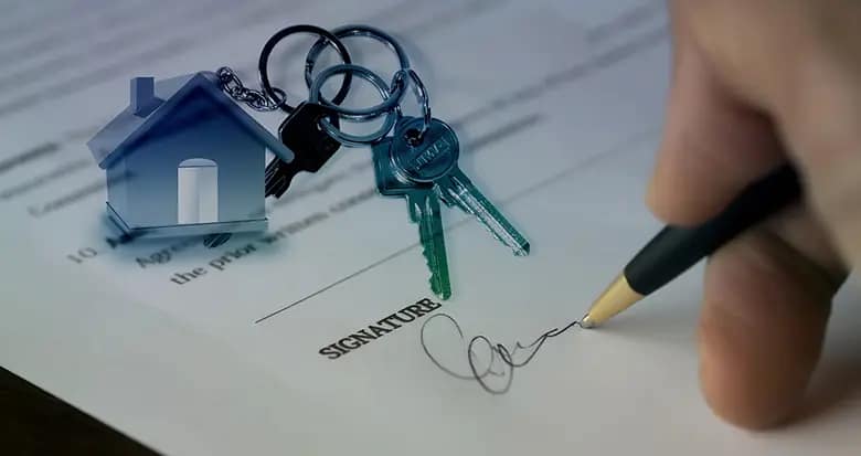 Persona firmando un contrato inmobiliario