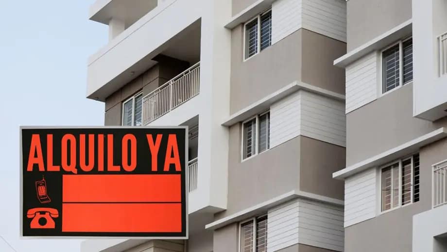La imagen muestra a un edificio de apartamentos y al frente un letrero que lee "alquilo ya".