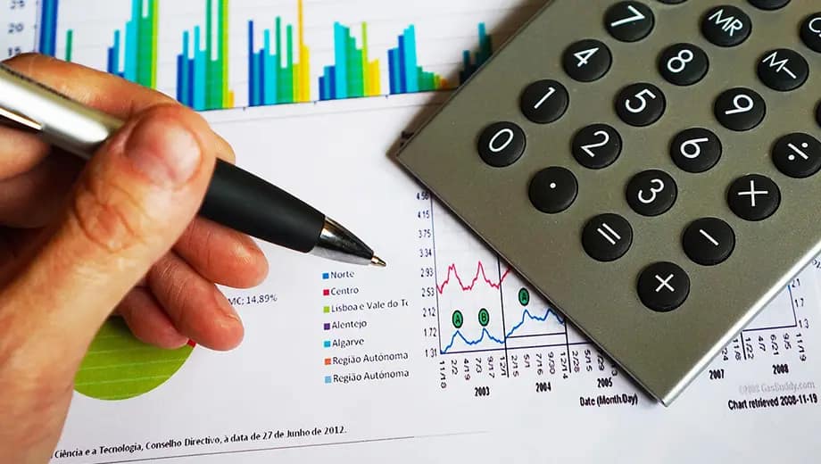 La imagen muestra a una persona haciendo cuentas con una calculadora.